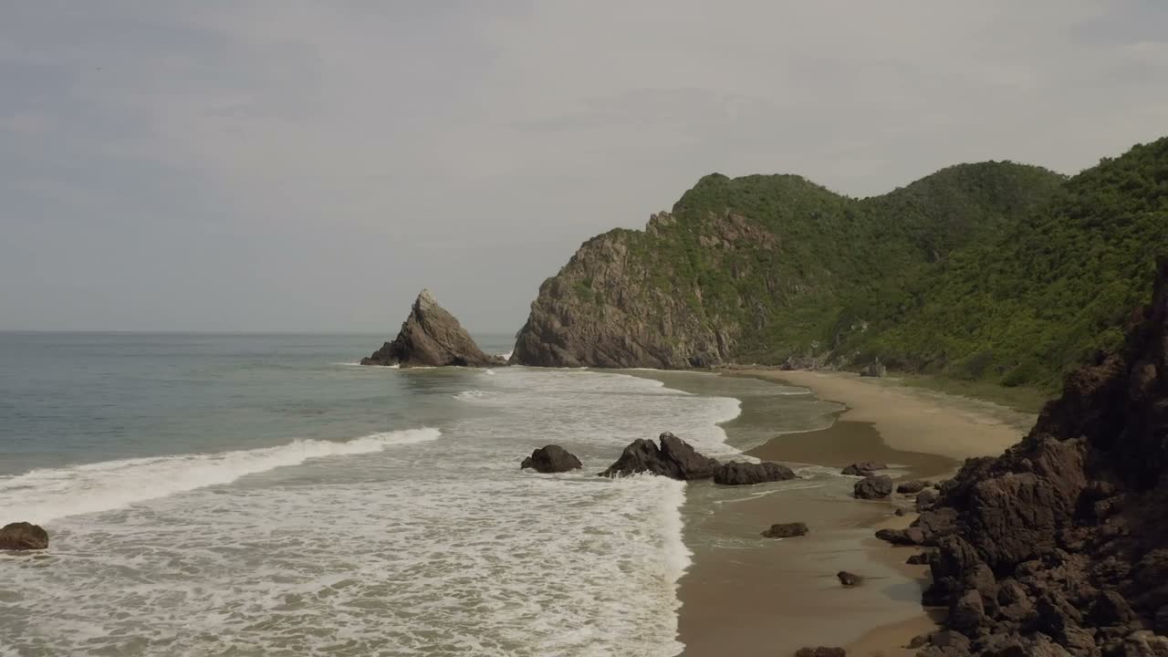 A sweeping coastline where green mountains meet the ocean